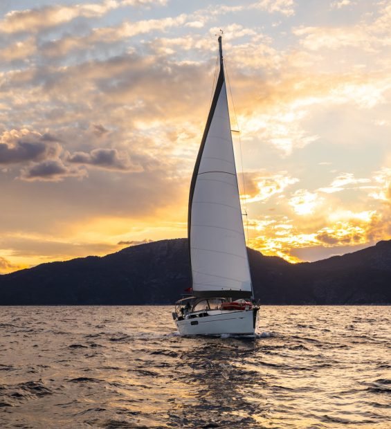 Yacht sailing at sunset. Luxury vacation at sea.